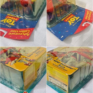 May include: A plastic action figure of Buzz Lightyear from the Toy Story franchise. The figure is wearing a red and white space suit and is holding a yellow laser gun. The figure is packaged in a clear plastic blister pack with a blue and yellow cardboard backing. The packaging features the Toy Story logo and the text "Solar Patroller Buzz" and "Firing Sunbeam Missile!"