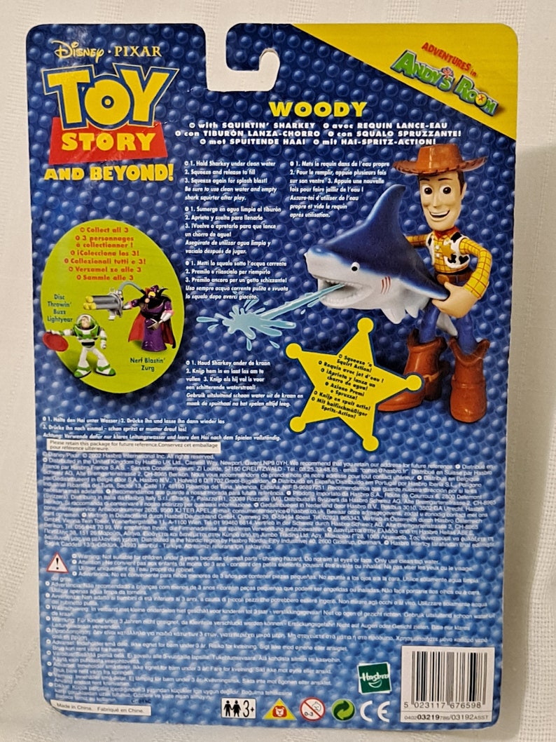 May include: Woody from Toy Story action figure holding a blue water squirting shark toy. The packaging features the Toy Story logo and the words "Adventures in Andy's Room".