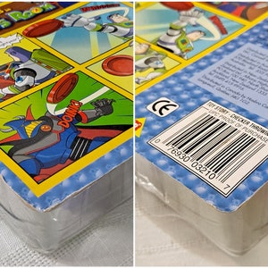 May include: Toy Story Checker Throwin' Buzz game box with a blue and red robot character on the front and a barcode on the back. The box is blue and yellow with a white background.