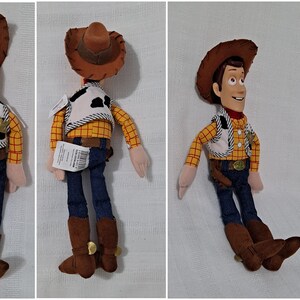 May include: A plush toy of Woody from the Toy Story franchise. Woody is wearing his signature cowboy hat, vest, and jeans. He has a friendly expression and is standing with his arms at his sides.