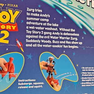 Pode incluir: Brinquedos de &aacute;gua Toy Story 2 com Woody e Buzz Lightyear. Os brinquedos s&atilde;o vermelhos e laranja e s&atilde;o mostrados submersos na &aacute;gua. A embalagem tem um fundo azul com estrelas e o logotipo do Toy Story 2.