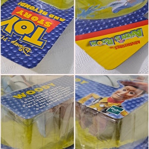 May include: A plastic package with a blue and yellow background featuring a Woody action figure from the Toy Story movie franchise. The package includes the text "Adventures in Andy's Room" and "Disney Pixar Toy Story And Beyond!" The figure is holding a water gun and has a red bandana around his neck.