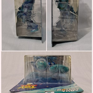 Peut inclure: Une figurine d'action en plastique bleue et verte de Buzz l'&Eacute;clair de la franchise de films Toy Story. La figurine est emball&eacute;e dans une bo&icirc;te en plastique transparent avec un dos en carton bleu et blanc. L'emballage pr&eacute;sente le logo Toy Story et les mots "Aqua Action". Le dos de l'emballage comprend une garantie limit&eacute;e de 2 ans et des informations pour les consommateurs.