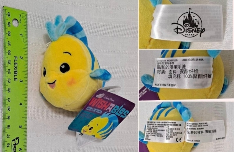 May include: Yellow and blue plush toy of a fish with a smiling face and sparkly eyes. The toy is labeled "Disney Parks" and "Wishables".