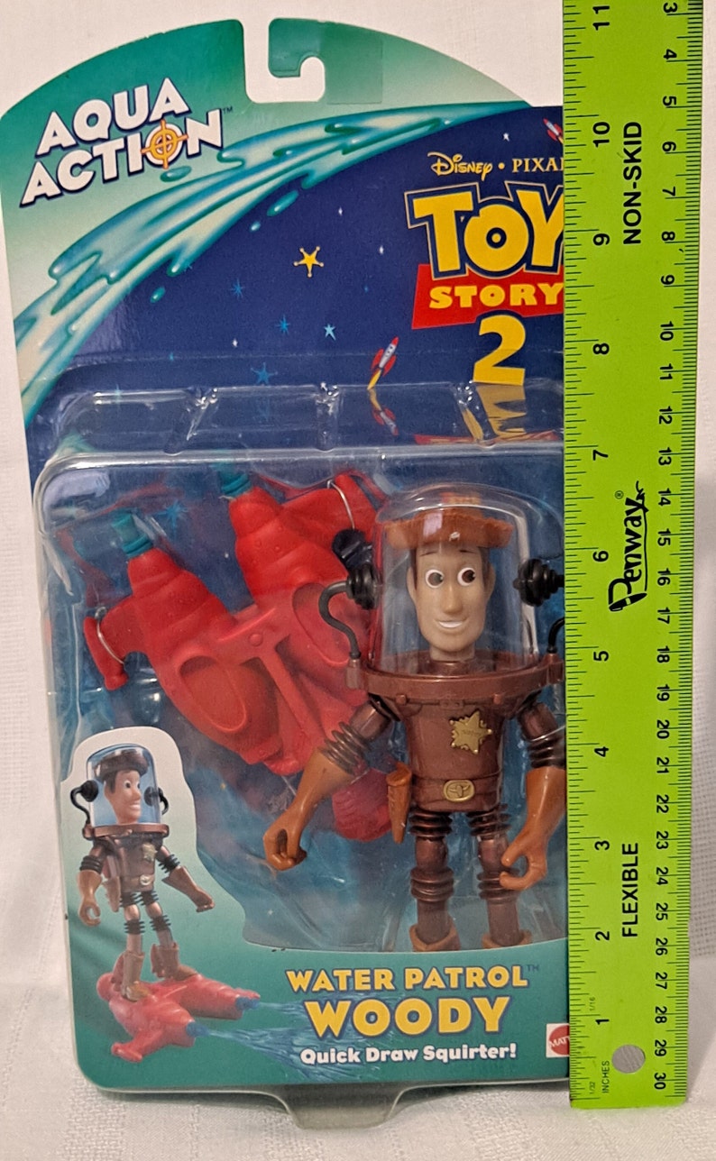 Pode incluir: Figura de a&ccedil;&atilde;o Toy Story 2 Water Patrol Woody com um esguicho de &aacute;gua vermelho. A figura est&aacute; usando um traje espacial marrom com um distintivo de estrela de xerife. A figura est&aacute; segurando uma pistola de &aacute;gua. A embalagem diz "Quick Draw Squirter!"