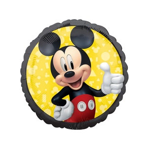 May include: A round foil balloon featuring a graphic of Mickey Mouse giving a thumbs up. The character wears red shorts with white buttons and white gloves. The background is a bright yellow circle with a pattern of small geometric shapes.