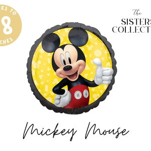 May include: A round foil balloon featuring Mickey Mouse giving a thumbs up against a yellow background with geometric shapes. The balloon has a black scalloped edge and text that reads "INFLATES TO 18 INCHES" and "the SISTERS COLLECTIVE" and "Mickey Mouse".