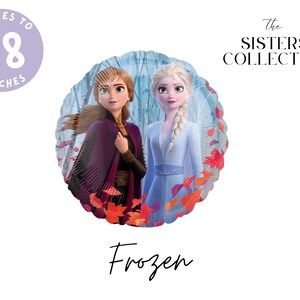 May include: A round foil balloon featuring Anna and Elsa from Frozen, surrounded by red and orange autumn leaves. The balloon text states it inflates to 18 inches. The Sisters Collective logo is visible in the top right corner, with Frozen below.
