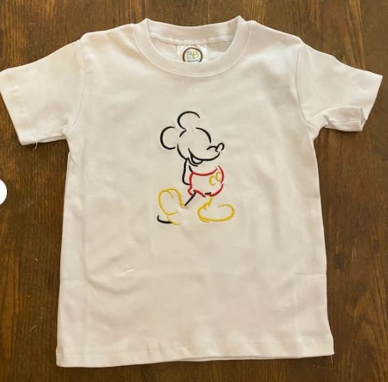 Op de afbeelding: Wit T-shirt met een zwarte en rode geborduurde omtrek van Mickey Mouse.