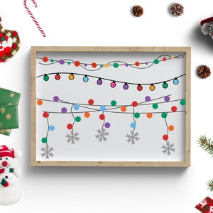 Puede incluir: Una ilustraci&oacute;n enmarcada de una cadena de luces navide&ntilde;as de colores con copos de nieve colgando debajo. El marco est&aacute; sobre un fondo blanco con otras decoraciones navide&ntilde;as alrededor.