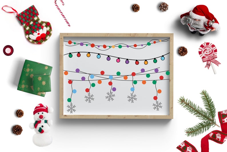 Puede incluir: Una ilustraci&oacute;n enmarcada de una cadena de luces navide&ntilde;as de colores con copos de nieve colgando debajo. El marco est&aacute; sobre un fondo blanco con otras decoraciones navide&ntilde;as alrededor.
