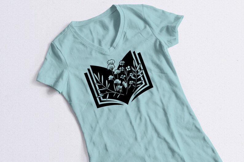 May include: A light blue t-shirt with a black graphic of an open book with flowers growing from the pages.