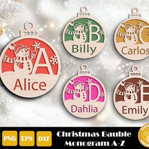 May include: Wooden Christmas bauble ornaments with a snowman design and personalized names. Each ornament features a different letter and name, such as "Alice" and "Billy". The ornaments are in various colors, including red, green, yellow, pink, and brown.