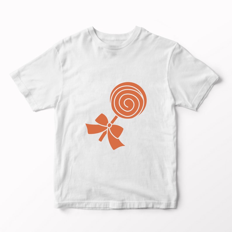 May include: A white short-sleeved t-shirt featuring a centred graphic of an orange spiral lollipop. The lollipop design includes a stick and a decorative bow tied around the base of the candy, rendered in a solid orange colour against the white fabric.
