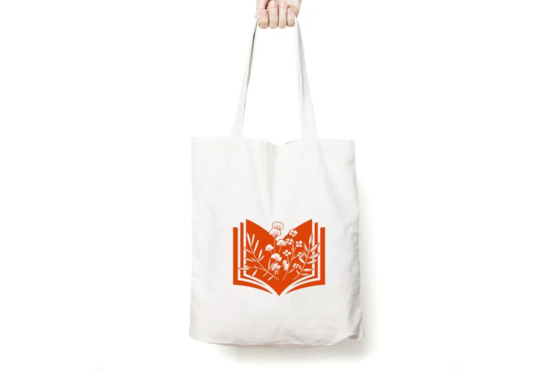 May include: A white tote bag with orange handles and a design of an open book with flowers inside.