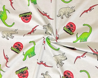 Tela de punto jersey 100% algodón con estampado de parque de dinosaurios blancos, cortada a medida.