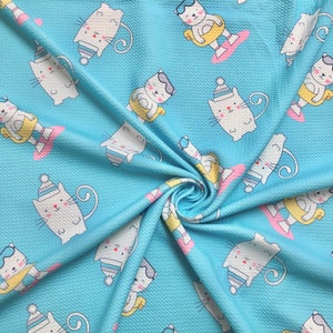 May include: A blue fabric with a repeating pattern of white cats wearing sunglasses and life preservers. The cats are all in different poses and have different expressions.