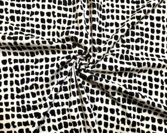 May include: Black and white fabric with a repeating pattern of small, irregular black shapes on a white background.