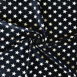 May include: Navy blue fabric with a repeating pattern of white five-pointed stars. The fabric is slightly gathered, creating soft folds and shadows. The stars are evenly spaced across the material.