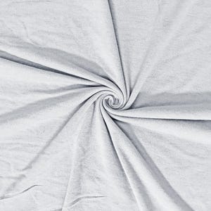 May include: A close-up shot of a light gray fabric, tightly swirled in the center. The fabric has a soft, textured appearance with visible folds and creases. The overall effect is of a smooth, flowing material.