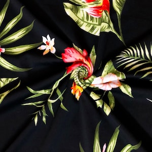 May include: Black fabric with a vibrant tropical floral pattern. The design features red, pink, and white flowers, along with green and yellow leaves. The fabric is folded, creating a dynamic visual texture.