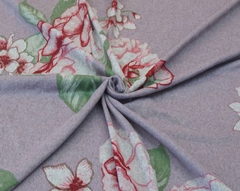 Könnte beinhalten: Nahaufnahme eines weichen, violetten Stoffes mit Blumenmuster. Der Stoff zeigt ein sich wiederholendes Muster aus rosa und weißen Blumen mit grünen Blättern.