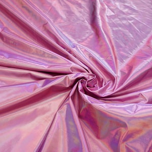 May include: Close-up of iridescent pink fabric with a smooth, shiny texture. The fabric is folded and draped, creating a soft, flowing effect.
