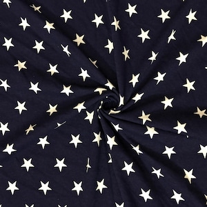 May include: Dark navy blue fabric with a repeating pattern of white five-pointed stars. The fabric is gathered in the center, creating a swirling effect. This textile is suitable for various crafting projects.