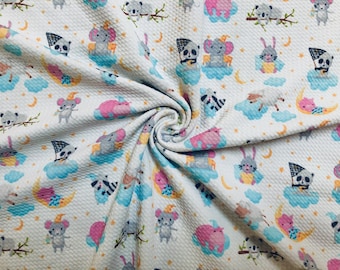 May include: White fabric with a repeating pattern of various animals, including a koala, a mouse, a rabbit, a pig, and a raccoon. The animals are depicted in a cartoon style and are surrounded by clouds and stars. The fabric has a textured surface.