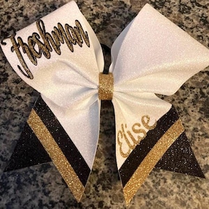 Cheerleading bow with class on upper loop. "Freshman "on upper loop. Black and Gold custom cheerleading hair accessory.