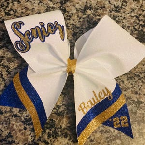 Full glitter white Senior Night Bow with royal blue and gold accent colors.