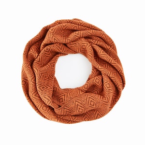 May include: A brown infinity scarf with a geometric pattern.