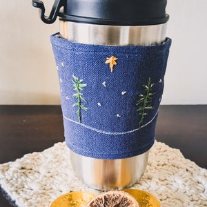 Collezione invernale calda: file da ricamo con fiocchi di neve, ghirlande e pini; Cartamodello PDF Cup Cozy, scheda grafica stampabile per Cup Cozy.