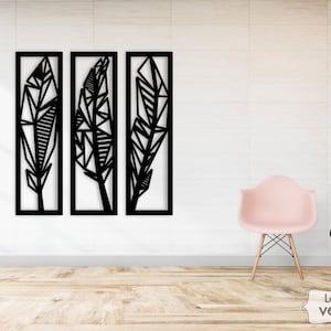 May include: Three black geometric feather wall decor pieces with a white background. The feathers are made of geometric shapes and are arranged in a vertical pattern.