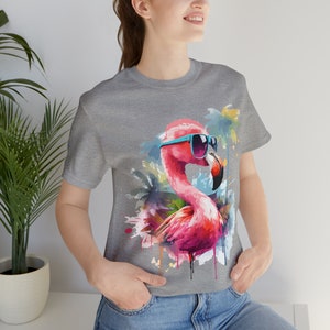 May include: A grey t-shirt with a pink flamingo wearing blue sunglasses and a watercolor background of palm trees.