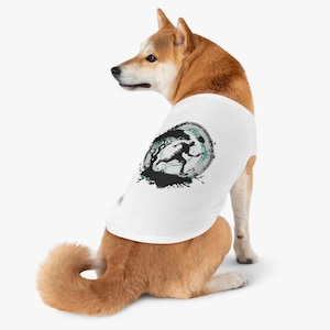 May include: White dog wearing a white tank top with a black and green graphic of a person running in a circle with a tree and a moon.