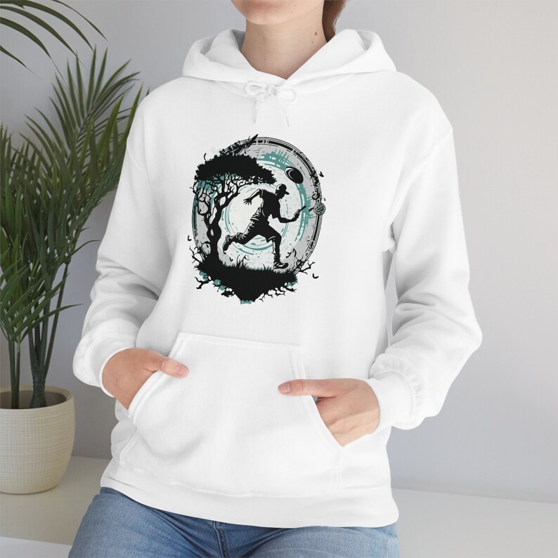May include: White hoodie with a graphic print of a person running through a forest with a glowing circle around them.