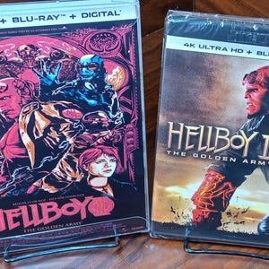 May include: Two sealed Blu-ray movie cases. The first features a red and black graphic with the title "Hellboy: The Golden Army." The second case is for "Hellboy II: The Golden Army," with a red-skinned character on the cover. Both cases have "4K Ultra HD + Blu-ray + Digital" text.