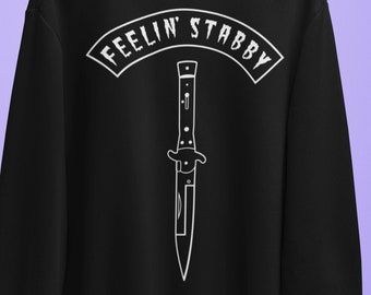 May include: Black sweatshirt with a white graphic of a knife and the text "Feelin' Stabby" in a white banner.