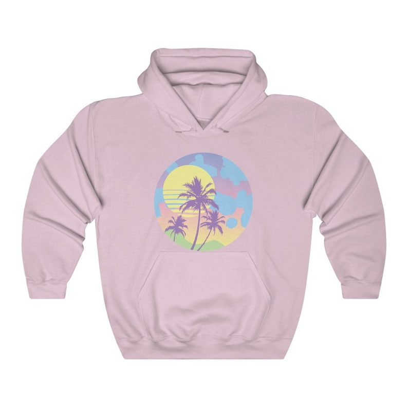 May include: A pink hoodie with a graphic of a sunset with palm trees in a circle. The graphic is in pastel colors of pink, blue, yellow, and green.