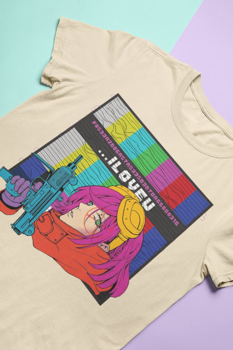 May include: A beige t-shirt with a graphic print of a woman with pink hair holding a gun. The graphic is set against a background of colorful, pixelated squares. The text "...ILOVEU" is printed on the graphic.