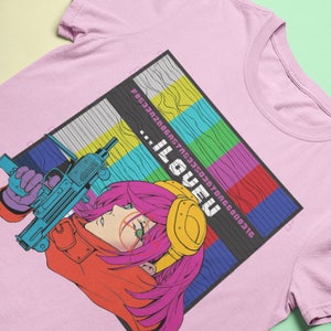 May include: Pink t-shirt with a graphic of a woman with pink hair holding a gun. The graphic is in a retro style with a pixelated background and the text "...ILOVEU" in a pixelated font.
