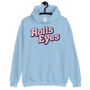Puede incluir: Sudadera con capucha azul claro con un gr&aacute;fico rosa "Rolls Eyes" en la parte delantera.