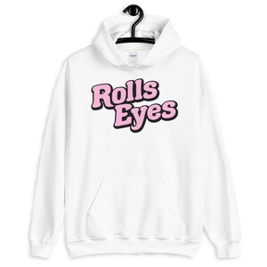 Puede incluir: Sudadera con capucha blanca con un gr&aacute;fico rosa y negro que dice "Rolls Eyes" en la parte delantera.