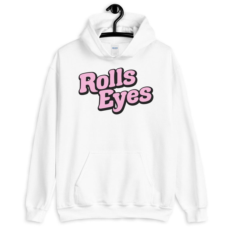 Puede incluir: Sudadera con capucha blanca con un gr&aacute;fico rosa y negro que dice "Rolls Eyes" en la parte delantera.