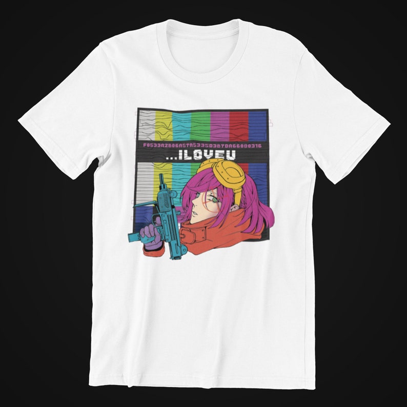 May include: White t-shirt with a graphic of a pink-haired anime character holding a gun. The character is wearing a red scarf and yellow goggles. The graphic is set against a background of a static television screen with the text "...ILOVEU" in the center.