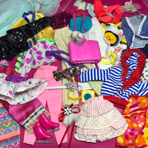 May include: A collection of colorful clothing items, including a pink and white striped skirt, a red and blue striped sweater, a pink and white dress, and a red and white striped shirt. There are also several accessories, such as a pink purse, a blue purse, and a pair of pink and white striped gloves.