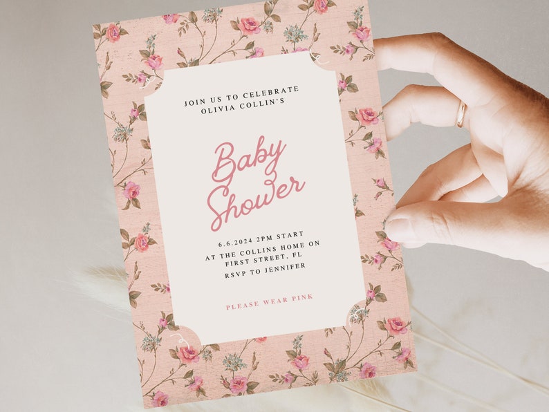 May include: A pink floral baby shower invitation with the text "Join us to celebrate Olivia Collin's Baby Shower" and details about the event, including the date, time, location, and RSVP information. The invitation also includes the text "Please wear pink."