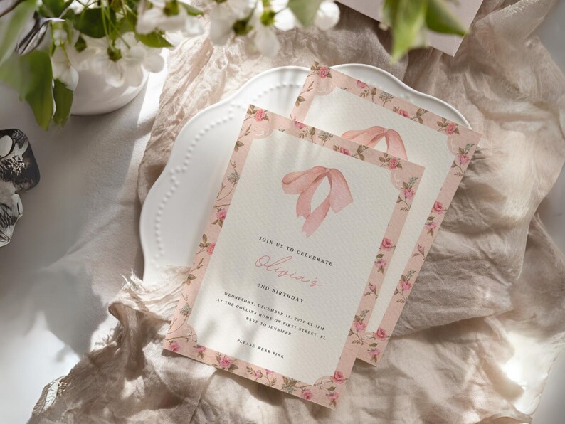 Pu&ograve; includere: Un invito floreale rosa con un fiocco di nastro rosa. L'invito recita "Unisciti a noi per celebrare il 2&deg; compleanno di Olivia. Mercoled&igrave; 1&deg; dicembre 2015 alle 15:00 presso la Collins Home in First Street, FL. A Jennifer. Per favore, indossa il rosa."