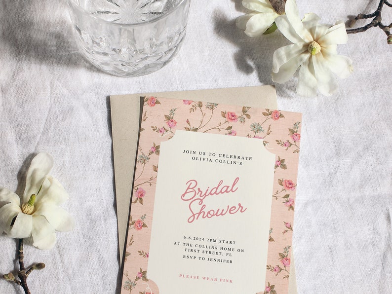 May include: A pink floral bridal shower invitation with the text "JOIN US TO CELEBRATE OLIVIA COLLIN'S Bridal Shower 6.6.2024 2PM START AT THE COLLINS HOME ON FIRST STREET, FL RSVP TO JENNIFER PLEASE WEAR PINK"